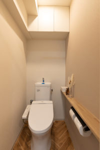 洗面室と同じヘリンボーンからの床がアクセントの清潔感あるトイレ
